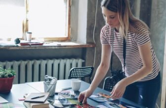 Small business owner arranging photographs and printed marketing materials on a desk
