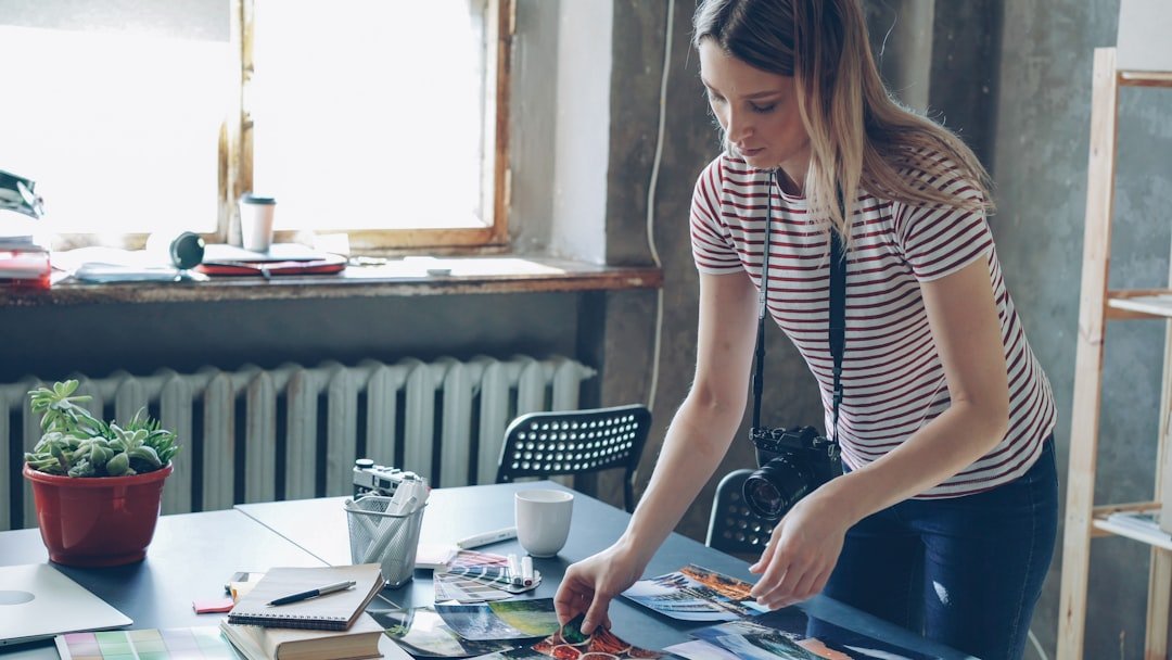 Small business owner arranging photographs and printed marketing materials on a desk