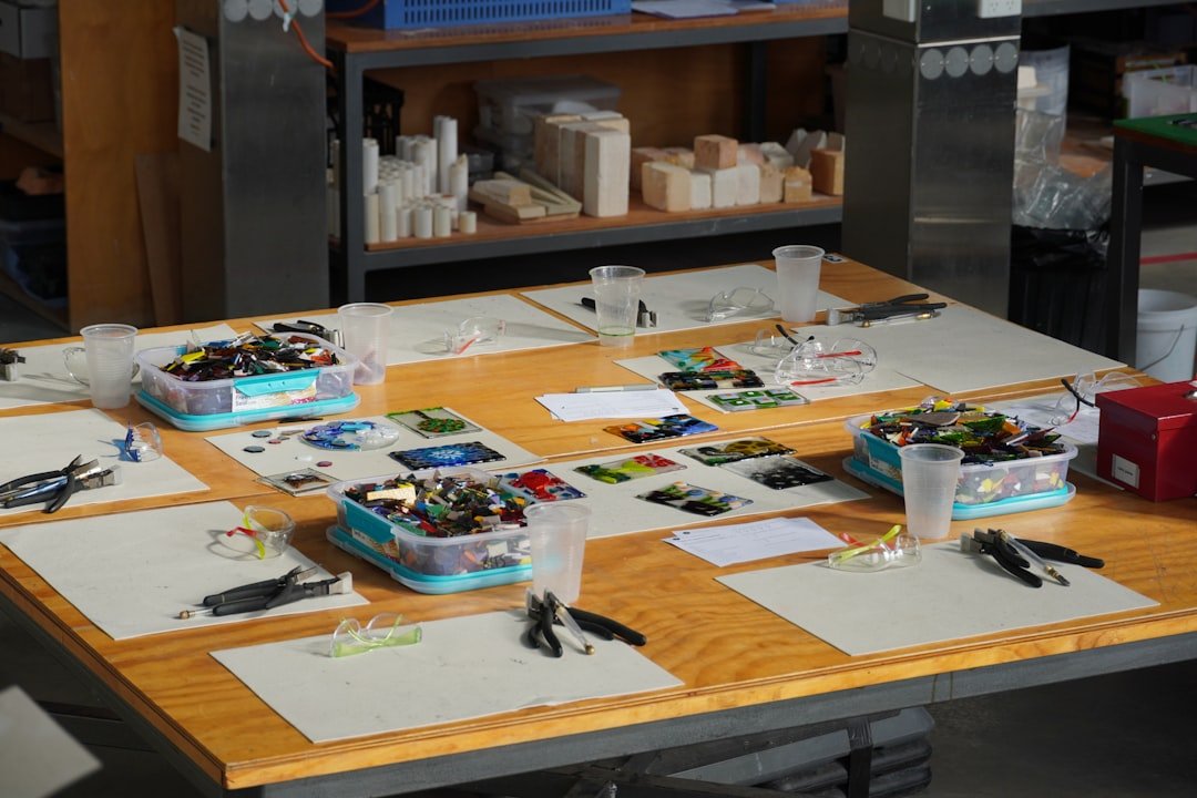 Craft workspace with mosaic tiles and art materials arranged on a table